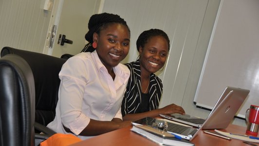 Two sitting women smiling into the camera