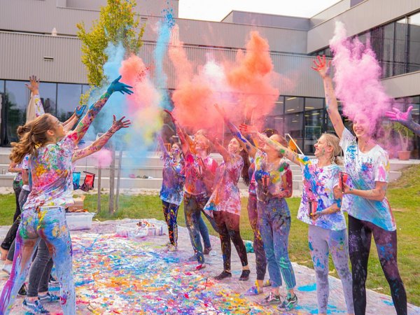 Kinder werfen bunte Farbpigmente in die Luft