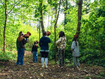 Jugendliche nehmen mit Mikrofonen Geräusche im Wald auf