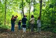 Jugendliche nehmen mit Mikrofonen Geräusche im Wald auf