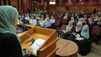 Female speaker at symposium in front of audience