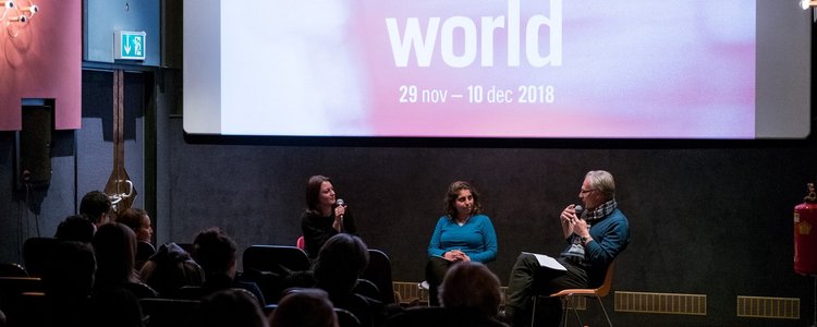 picture shows people in the cinema sitting, listening and watching the two panellists who are sitting in the front of the room