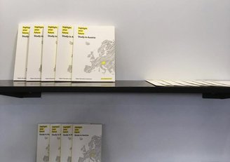 Infobroschüren und Kataloge im Österreichdesign am Messestand der EAIE-Messe in Genf.