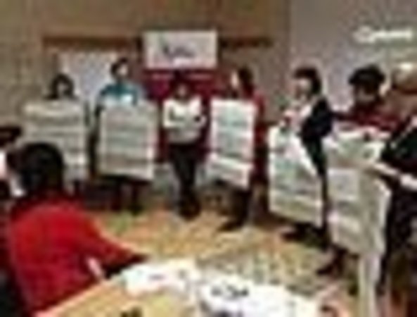 Sieben Frauen präsentieren Flipchartbögen mit Tagungsergebnissen