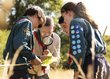 Eine Pfadfinder-Gruppe betrachtet mit einer Lupe Insekten.
