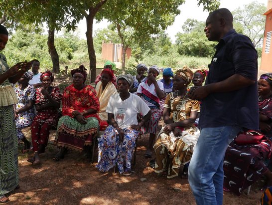 Group of sitting people looking at a standing woman and man