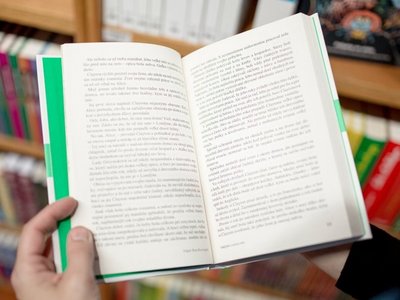 Person reading book in bookstore