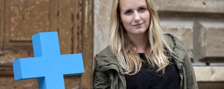 Eine Studentin hält ein blaues ErasmusPlus-Symbol mit einer Hand.