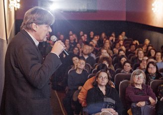 Andreas Obrecht, head of the APPEAR programme, is talking in the cinema in front of people