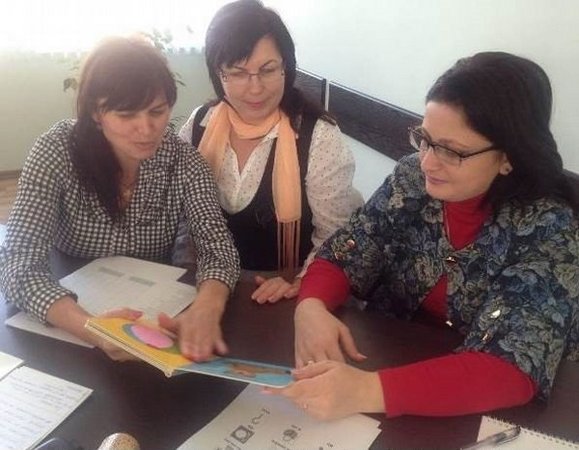 Drei Workshopteilnehmerinnen diskutieren am runden Tisch über Ergebnisse