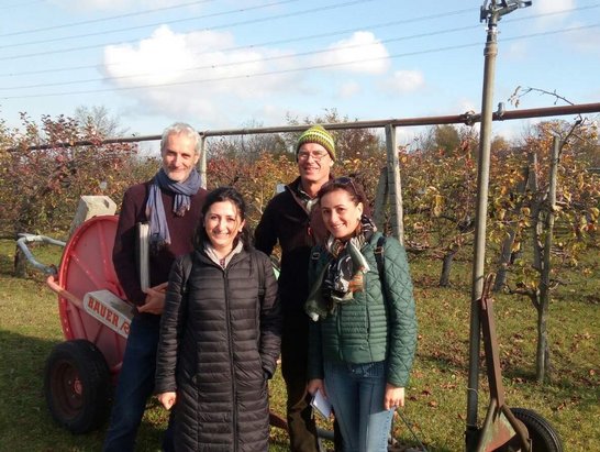 groop photo of visitors in front of orchard