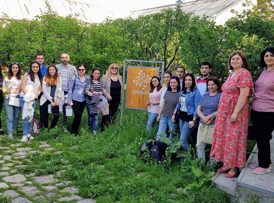 Group of people posing for a group picture next to a  NAIRIAN sign