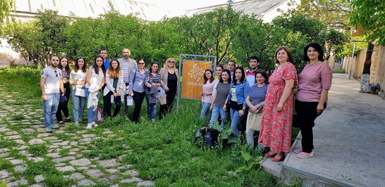 Group of people posing for a group picture next to a  NAIRIAN sign