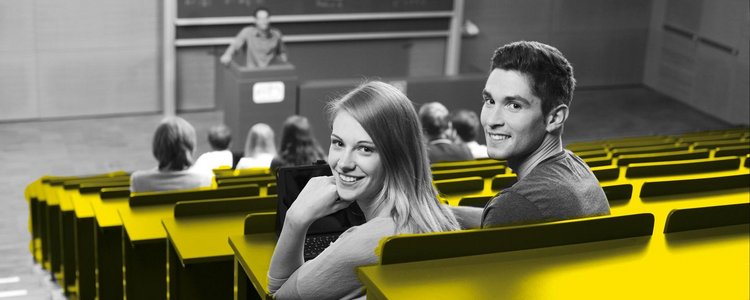 A student and a student are sitting in the lecture hall and laughing at the camera.