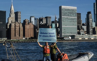Greenpeace activists are protesting on a boat in front of New York's skyline 