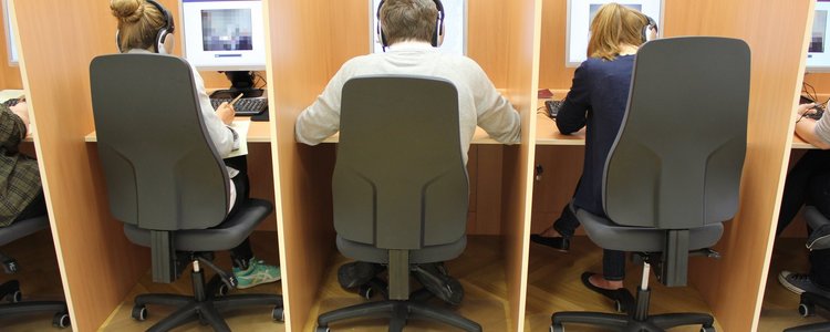 3 Personen mit dem Rücken zugewandt arbeiten an ihren PCs