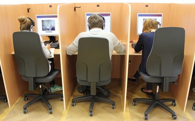 3 Personen mit dem Rücken zugewandt arbeiten an ihren PCs