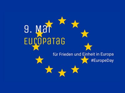 Die EU-Flagge, durchzogen mit der Aufschrift "9. Mai Europatag | für Frieden und Einheit in Europa #EuropeDay"