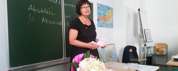 Margarete Kernegger steht in einem Klassenzimmer vor der Tafel.