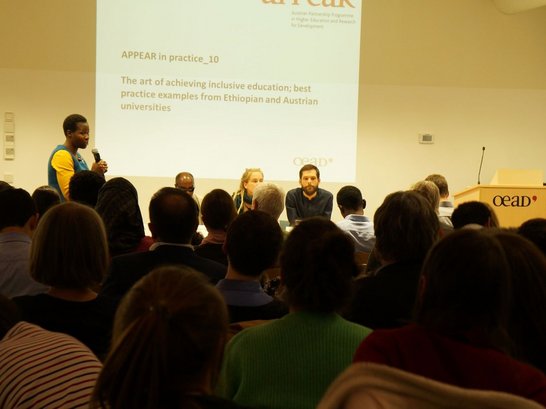 Moderator is standing and talking to the audience