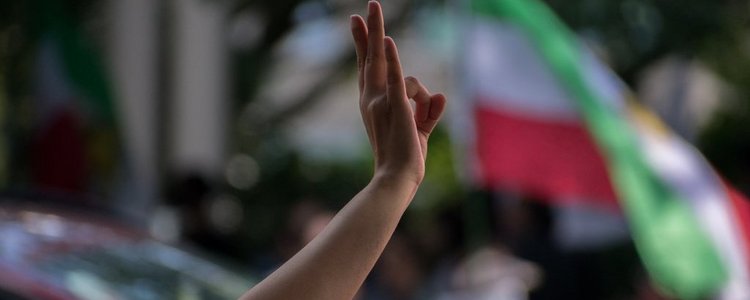 Hand in der Luft vor iranischer Flagge
