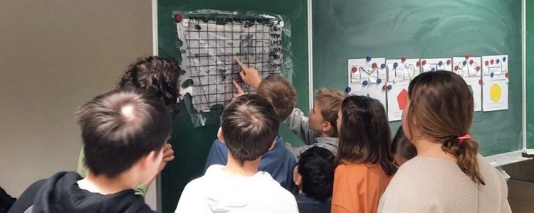 Kinder betrachten eine Tafel mit Rätsel
