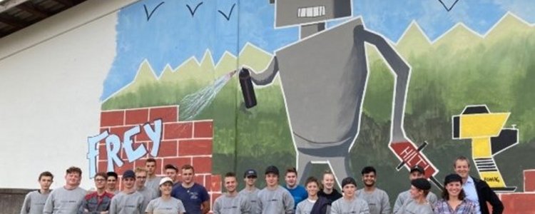 Jugendliche vor einer Wand mit Grafitti