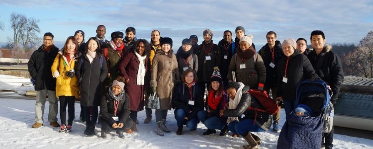 Eine Gruppe Studierender unterschiedlicher Herkunft stehen im Schnee. 