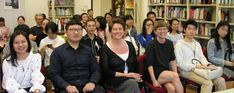 Zuhörerinnen und Zuhörer bei der Award Ceremony China, die auf Sesselreihen in einer Bibliothek sitzen und in die Kamera blicken
