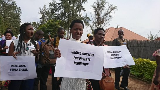 Group of poeople demonstrating and holding white posters and slogans in their hands