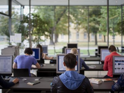 Klassenraum mit Schülern vor Bildschirmen