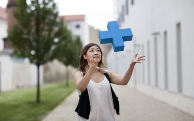Junge Frau fängt ein blaues Erasmus Logo