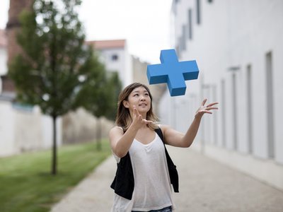 Junge Frau fängt ein blaues Erasmus Logo