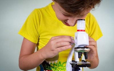 Schüler untersucht eine Probe unter dem Mikroskop