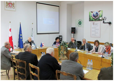 Group of people sitting at tables arranged in a U-shape