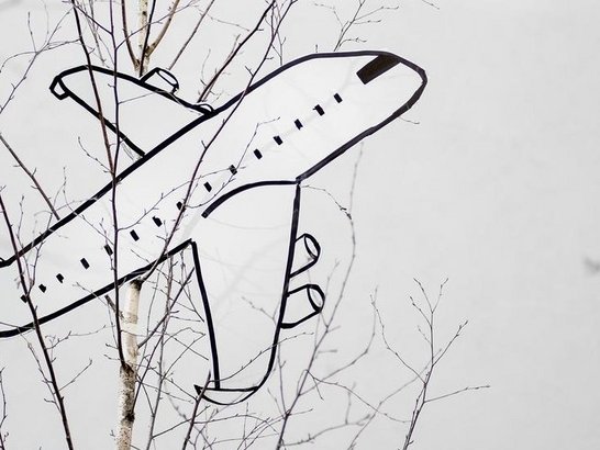 Flugzeug aus Karton hängt in einem Baum