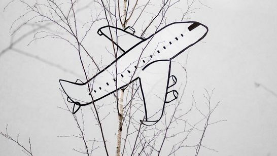 Flugzeug aus Karton hängt in einem Baum