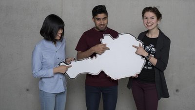 Drei Personen mit Österreichkarte aus Karton