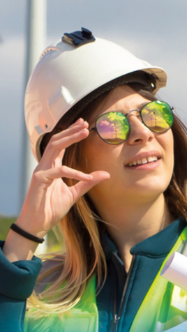 A young woman in a helmet looks at the sun