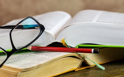 Zwei Bücher, daneben eine Brille und ein Stift